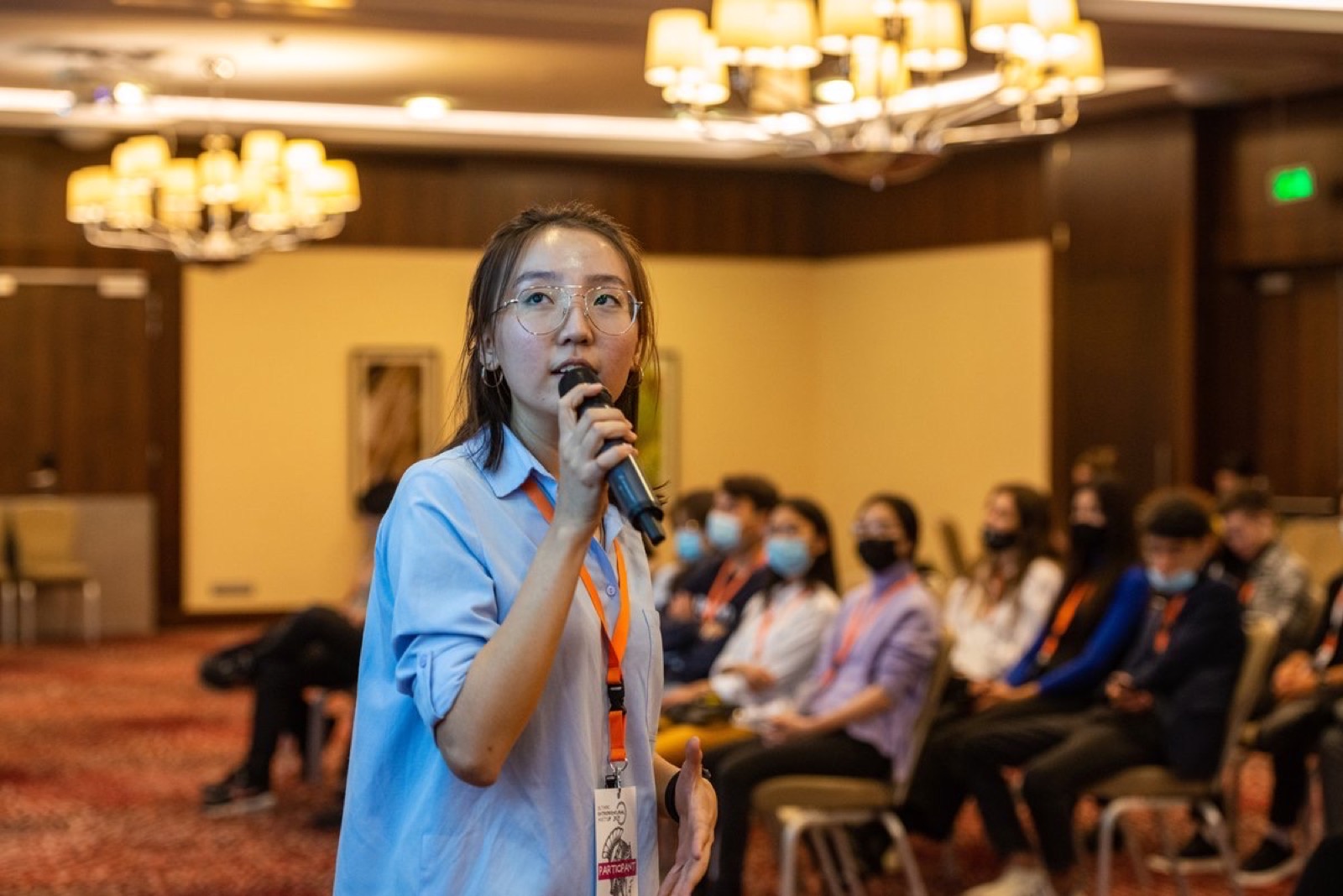 Speaking into a microphone at a conference